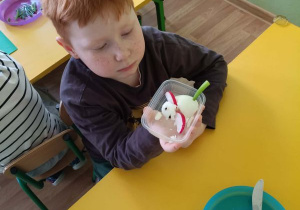 Chłopiec prezentuje wykonaną przez siebie myszkę z jajka