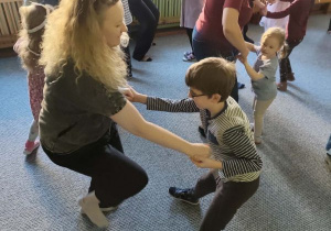 Rodzice i dzieci podczas zabaw integracyjnych tańczą w parach