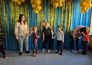 Dzieci stoją ze swoimi rodzicami