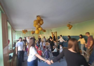 Rodzice tworzą duże koło na zewnątrz, dzieci podają sobie ręce w środku