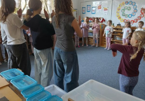 Dzieci stoją w kręgu i powtarzają rymowankę po prowadzących zajęcia