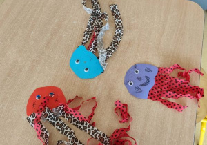 Na stoliku leżą wykonane przez dzieci meduzy