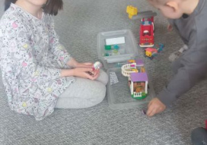 Dziewczynka z chłopcem budują z klocków Lego