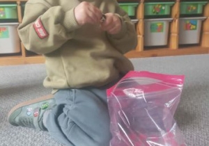 Chłopiec buduje ze swoich klocków Lego