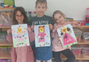 Dziewczynki prezentują swoje prace przedstawiające postacie Lego