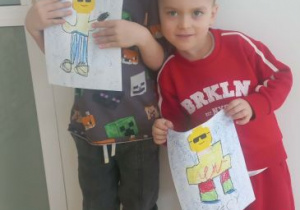 Chłopcy prezentują swoje prace przedstawiające postacie z Lego