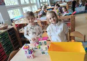 Dziewczynki bawią się przy stoliku klockami Lego
