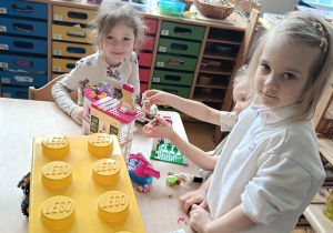 Dziewczynki bawią się przy stoliku klockami Lego