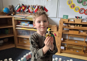 Chłopiec pozuje do zdjęcia z flamingiem z klocków Lego