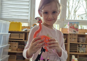 Dziewczynka pozuje do zdjęcia z flamingiem z klocków Lego