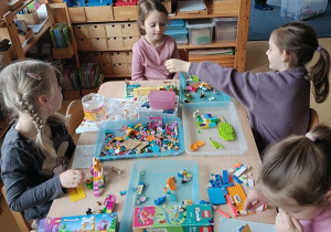 Dziewczynki bawią się przy stoliku klockami Lego