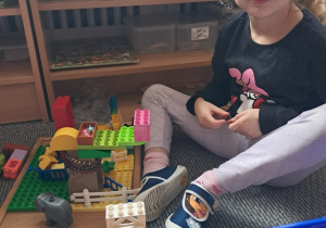 Dziewczynka w czasie zabawy klockami lego