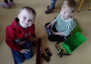 Chłopcy konstruują budowle z klocków LEGO.