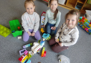 Dziewczynki wspólnie budują z klocków LEGO.