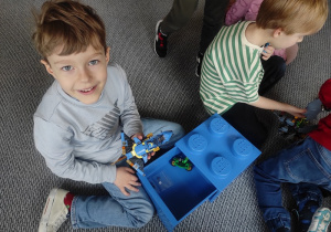 Chłopiec prezentuje swoją rakietę z klocków LEGO.