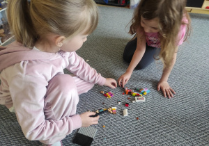 Dziewczynki wspólnie bawią się klockami LEGO.