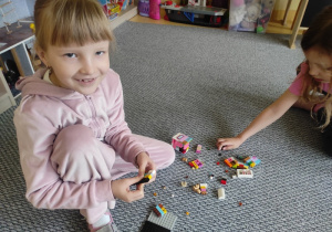 Dziewczynka prezentuje swoje klocki LEGO.
