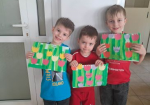 Chłopcy prezentują swoje prace plastyczne przedstawiające tulipany