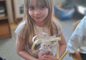 Dziewczynka pozuje do zdjęcia z prezentem