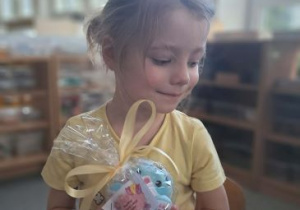 Dziewczynka pozuje do zdjęcia z prezentem