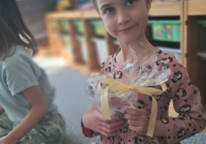 Dziewczynka pozuje do zdjęcia z prezentem