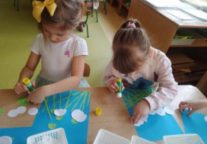 Dziewczynki przyklejają łodygi kwiatów