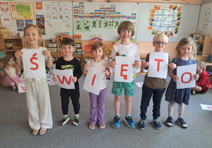 Dzieci prezentują samodzielnie przygotowany napis "Święto Konstytucji 3 Maja"