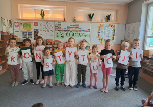 Dzieci prezentują samodzielnie przygotowany napis "Święto Konstytucji 3 Maja"