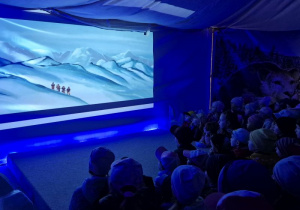 Dzieci oglądają film wyświetlany w lodowej krainie