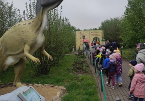 Dzieci podziwiają dinozaury.