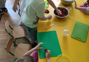 Dzieci wyjmują truskawki z miski
