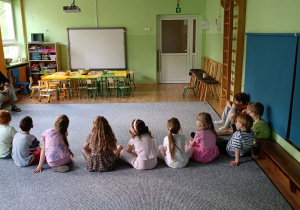 Dzieci siedzą na dywanie