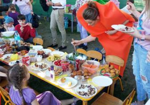 Dzieci i rodzice przy stole piknikowym
