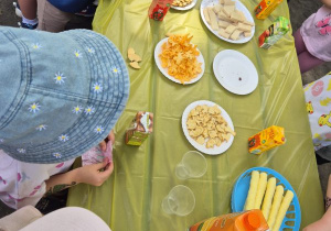 Dzieci uczestniczą w słodkim poczęstunku w ogrodzie przedszkolnym
