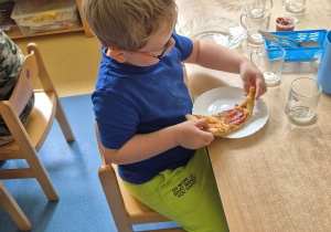 Chłopiec je pizzę