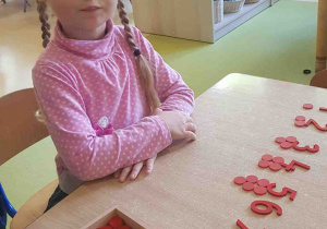 Dziewczynka układa liczby, dzieląc je na parzyste i nieparzyste