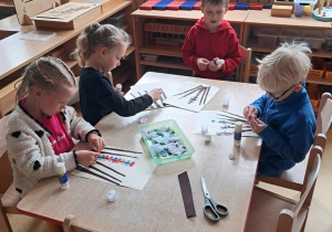 Starszaki podczas ozdabiania wielkanocnej palemki