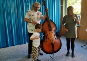 Chłopiec gra na instrumencie z pomocą muzyka