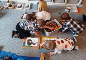 Dzieci samodzielnie układają ramki wokół portretu Marii Montessori