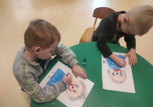 Chłopcy rysują portret Marii Montessori.