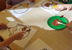 Dzieci korzystają z widelca, aby wyczarować igły jeżowi