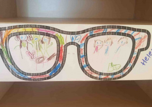 W okularach narysowano wesołe dzieci z pieskiem