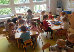 Dzieci pracują przy stolikach, dbają o porządek