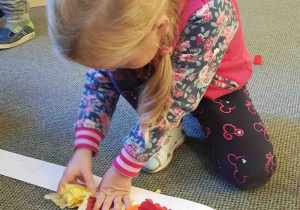 Dziewczynka przykleja papierowe serwetki do opaski