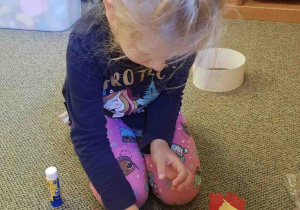 Dziewczynka przykleja papierowe kolorowe serwetki