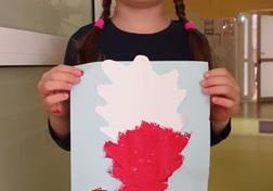 Nela prezentuje wykonaną przez siebie pracę plastyczną - brzoza z biało-czerwoną koroną drzew