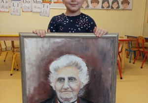 Dziewczynka trzymająca portret Marii Montessori