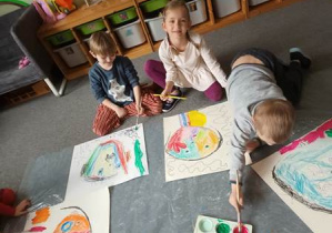 Dzieci na dywanie malują swoje obrazy w czasie realizacji jednego z zadań projektu "Sztuka w oczach dziecka"