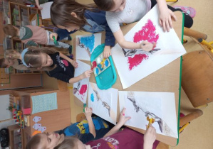 Dzieci przy stoliku stemplują tło do fragmentu fresku Michała Anioła