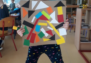 chłopiec prezentuje prace inspirowaną abstrakcją geometryczną